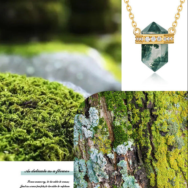 Green crystal pendant necklace with gold chain on a green background